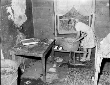 Daughter of the Elige Hicks washing in the kitchen of their four room house for which they pay $10.50 monthly. They... - NARA - 541035