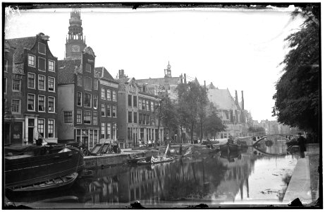 De Oudezijds Voorburgwal gezien in noordoostelijke richting naar de Oudekerksbrug (Brug 206) en het Oudekerksplein met de Oude Kerk. Links Oudezijds Voorburgwal 98, 96 en de ingang van de Sint Annenstraat photo