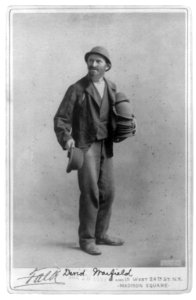 David Warfield, full length, standing, facing left; holding a stack of hats LCCN2005683738
