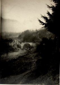 Die vom Feinde durch 2 Volltreffer halb zerstörte Steinbrücke über den Isonzo östlich von Tolmein während der Beschießung. Standpunkt, Unterhalb der Straße Kote 186, Aufgen, 11h vorm. (BildID 15466020)