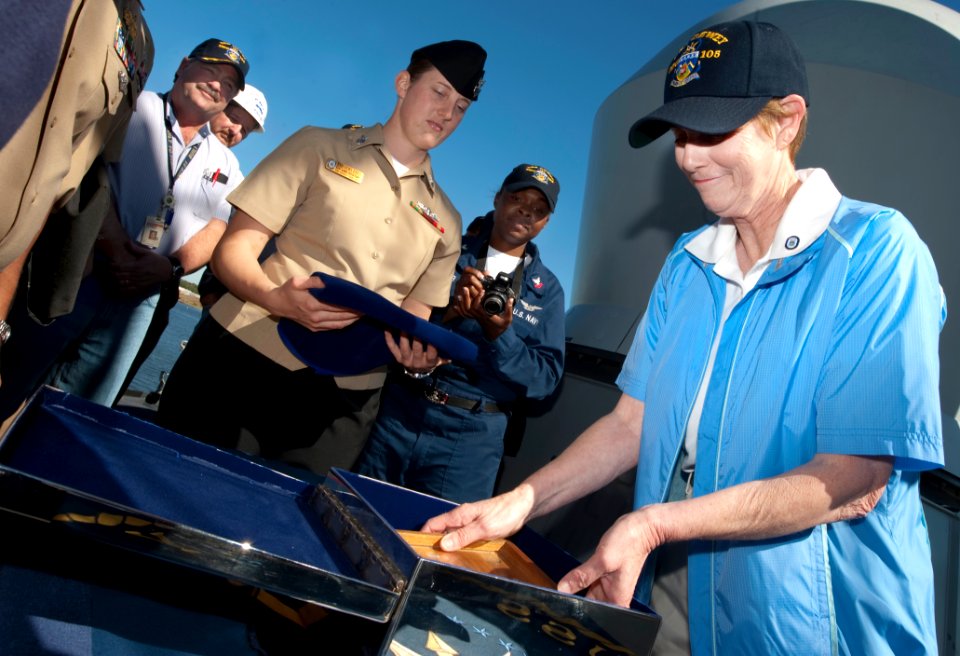 Deborah Mullen lays pieces of good luck into a steel box, 2009