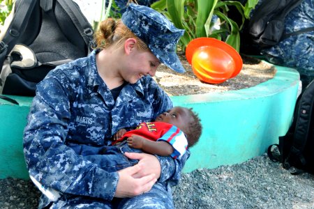 Defense.gov News Photo 100727-N-7680E-232 - U.S. Navy Yeoman 2nd Class Rachel Martis assigned to the amphibious assault ship USS Iwo Jima LHD 7 cradles a Haitian child during a community photo