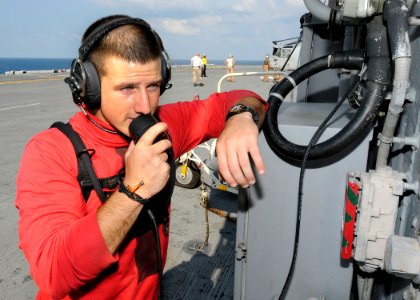 Defense.gov News Photo 100828-N-3154P-058 - U.S. Navy Petty Officer Chase Hickman checks a phone on the flight deck of the amphibious assault ship USS Kearsarge LHD 3 in the Atlantic Ocean