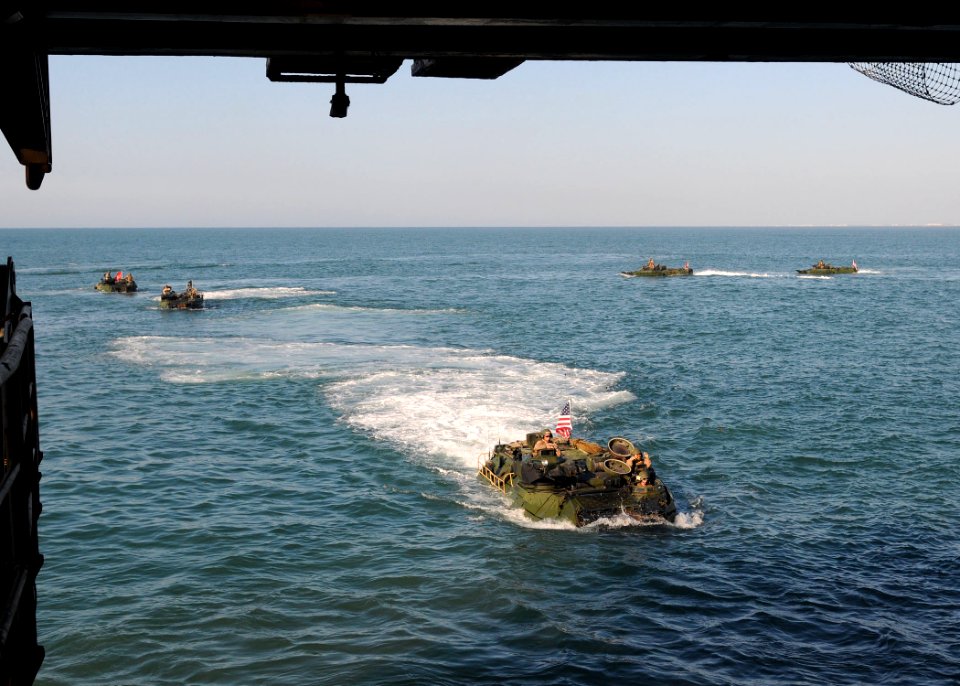 Defense.gov News Photo 100830-N-8069G-296 - U.S. Marine Corps amphibious assault vehicles prepare to enter the well deck of the amphibious dock landing ship USS Carter Hall LSD 50 while the