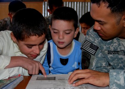 Defense.gov News Photo 101003-N-7062A-002 - U.S. Navy Petty Officer 1st Class Rodolfo Duqu right practices conversational English with children of Afghan National Army soldiers at Camp