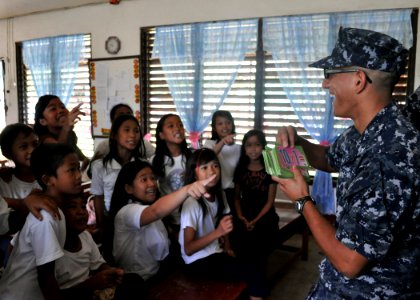 Defense.gov News Photo 101013-N-3620B-047 - U.S. Navy Petty Officer 3rd Class Johan Olarte plays a mathematics game with children during a community relations event at San Nicolas Elementary