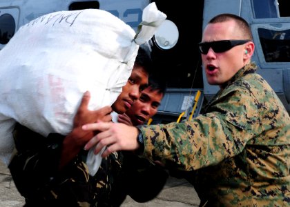 Defense.gov News Photo 101022-N-5538K-063 - U.S. Marine Corps Capt. Bill Woodward from the 31st Marine Expeditionary Unit directs Philippine service members while loading supplies into a