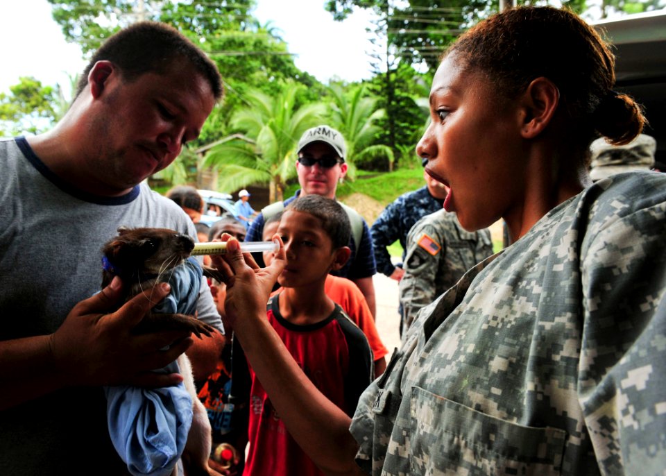 Defense.gov News Photo 100921-N-1531D-242 - U.S. Army Pfc. Angela McCormick right embarked aboard the multipurpose amphibious assault ship USS Iwo Jima LHD 7 administers a deworming
