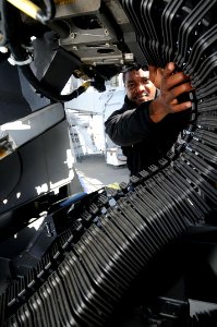 Defense.gov News Photo 101026-N-1854W-261 - U.S. Navy Petty Officer 2nd Class Terrance Davis assigned to the guided missile destroyer USS Mitscher DDG 57 loads a MK-38 machine gun while
