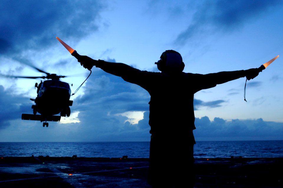 Defense.gov News Photo 100829-N-7478G-682 - Petty Officer 3rd Class Michael Sumlar signals launch to an SH-60F Seahawk helicopter aboard the 7th Fleet command ship USS Blue Ridge LCC 19 while