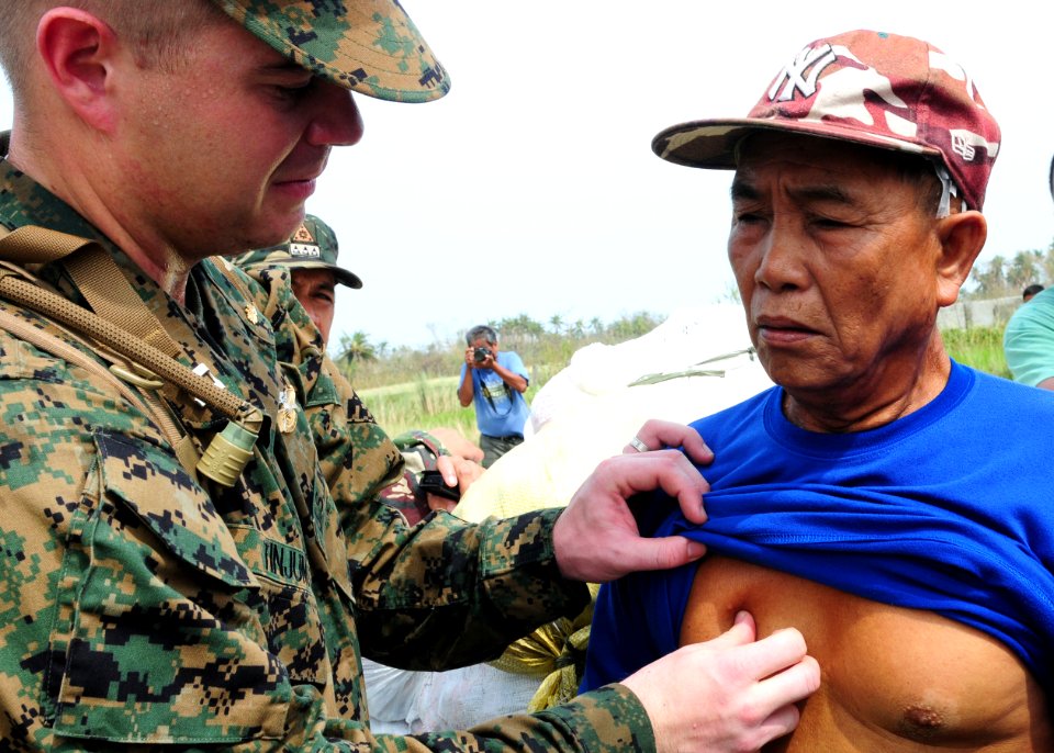 Defense.gov News Photo 101022-N-5538K-218 - U.S. Navy Lt. John M. Tinjum left a medical officer assigned to the 31st Marine Expeditionary Unit examines a man for injuries at an airfield in
