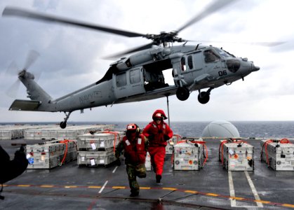Defense.gov News Photo 101202-N-7103C-126 - U.S. Navy Airman Erik Fischer and Petty Officer 3rd Class Ryan Caballero leave a staging area as an MH-60S Sea Hawk helicopter assigned to photo