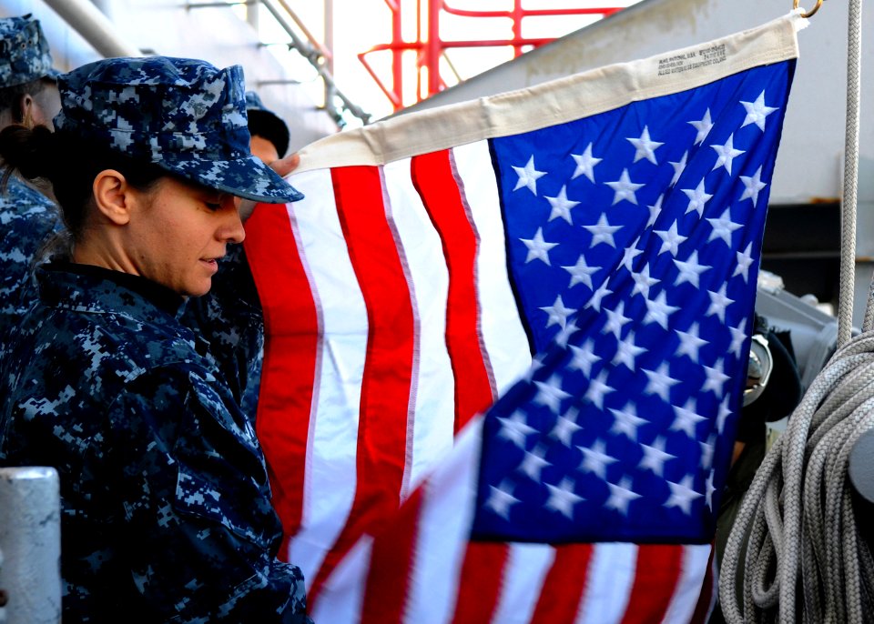 Defense.gov News Photo 110104-N-4590G-082 - U.S. Navy Quartermaster Seaman Ingrid Devinkayne prepares a national ensign to be raised as the aircraft carrier USS Ronald Reagan CVN 76 leaves