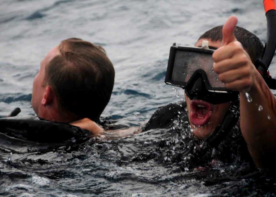 Defense.gov News Photo 101108-N-0120A-122 - U.S. Navy Petty Officer 3rd Class Andres Acosta right signals to a boat crew while rescuing Petty Officer 1st Class Kurt Bartholomai during search