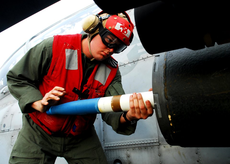 Defense.gov News Photo 101209-N-2218S-166 - U.S. Marine Corps Lance Cpl. Jeremy Booth loads a 2.75-inch rocket onto a U.S. Marine Corps AH-1W Super Cobra helicopter for a live-fire exercise