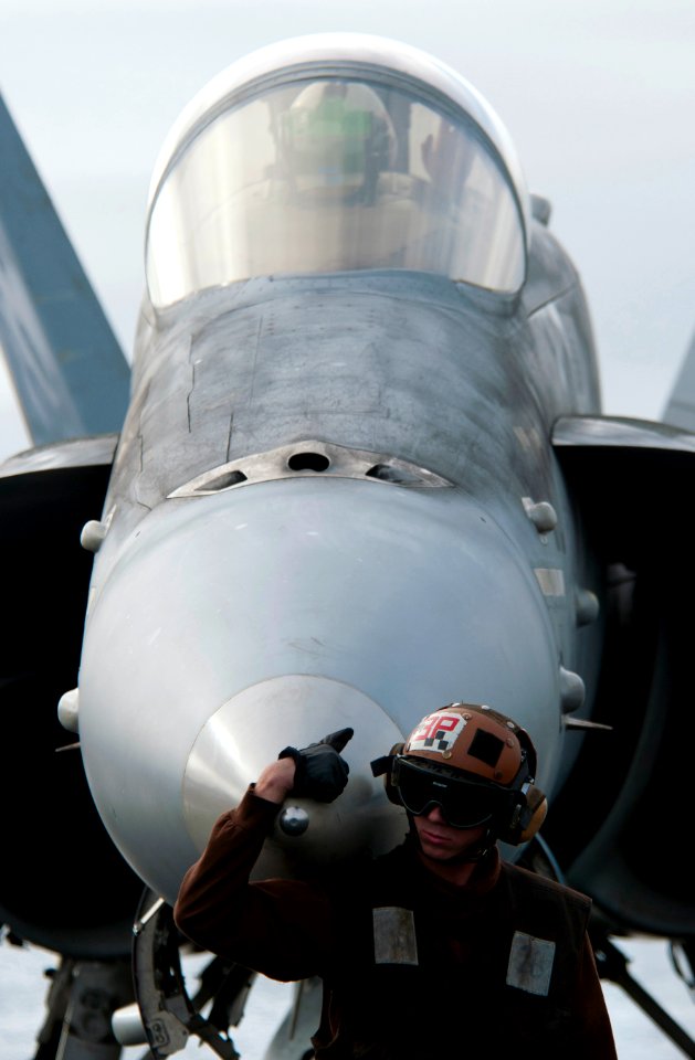 Defense.gov News Photo 101217-N-7981E-156 - Airman Tyler Signer a plane captain assigned to Strike Fighter Squadron 113 waits for the launch of an F A-18C Hornet after completing start up