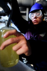 Defense.gov News Photo 110107-N-9132C-312 - U.S. Navy Airman David Chitwood takes a fuel sample from a sponson aboard the aircraft carrier USS Ronald Reagan CVN 76 during a replenishment at