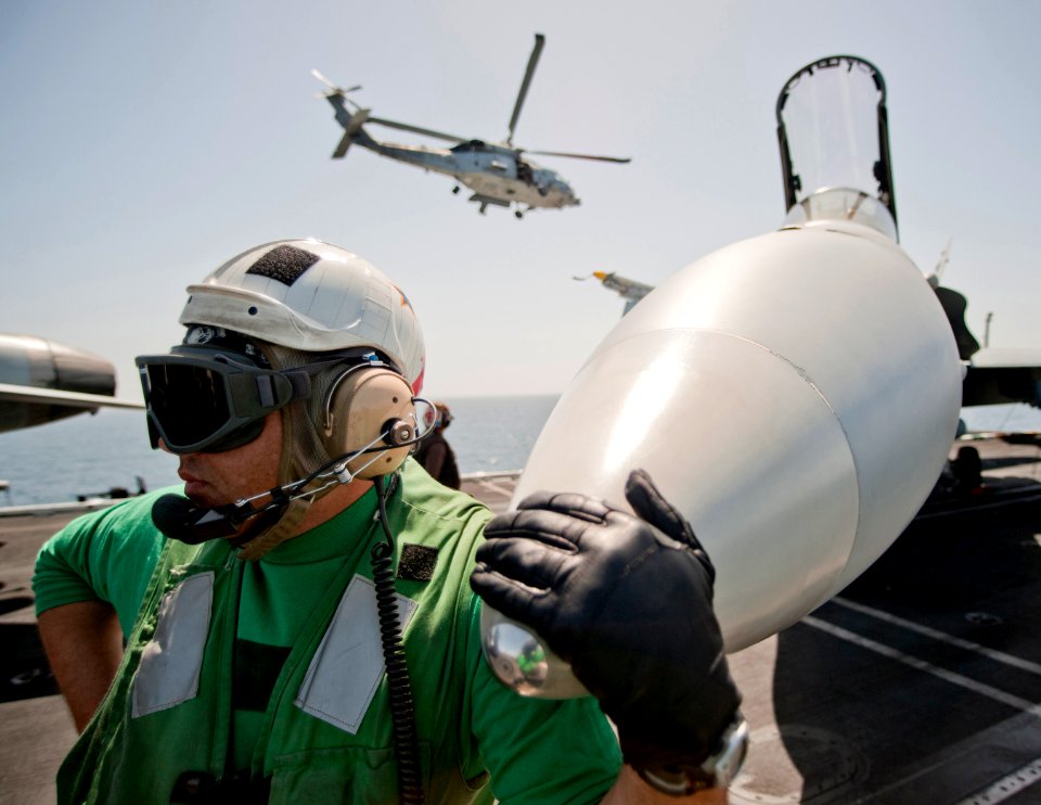 Defense.gov News Photo 110309-N-DR144-188 - Chief Petty Officer Todd Wing assigned to Strike Fighter Squadron 25 waits with an F A-18C Hornet as it is readied for a mission on the flight