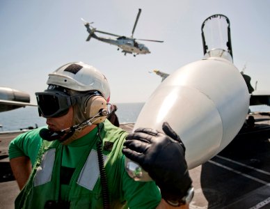 Defense.gov News Photo 110309-N-DR144-188 - Chief Petty Officer Todd Wing assigned to Strike Fighter Squadron 25 waits with an F A-18C Hornet as it is readied for a mission on the flight