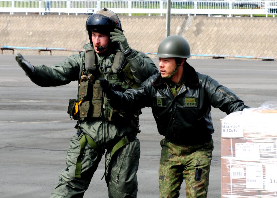 Defense.gov News Photo 110322-N-5538K-627 - Gunnery Sgt. Sam Carnes left and a member of the Japan Maritime Self-Defense Force direct the movement of humanitarian assistance and disaster