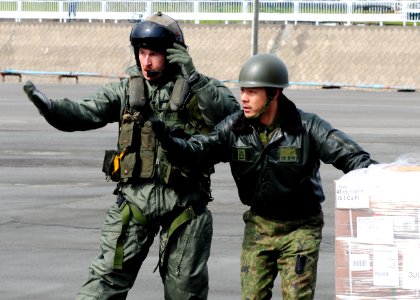 Defense.gov News Photo 110322-N-5538K-627 - Gunnery Sgt. Sam Carnes left and a member of the Japan Maritime Self-Defense Force direct the movement of humanitarian assistance and disaster