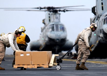 Defense.gov News Photo 110321-N-SO729-408 - U.S. Marines move humanitarian and disaster relief supplies to load them into a Marine Corps CH-46E Sea Knight helicopter on the flight deck of the
