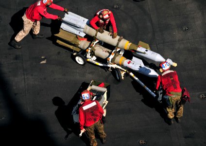 Defense.gov News Photo 110326-N-0074G-007 - Marines assigned to the aircraft carrier USS Enterprise CVN 65 push ordnance into place to arm an F A-18C Hornet assigned to Attack Squadron 251