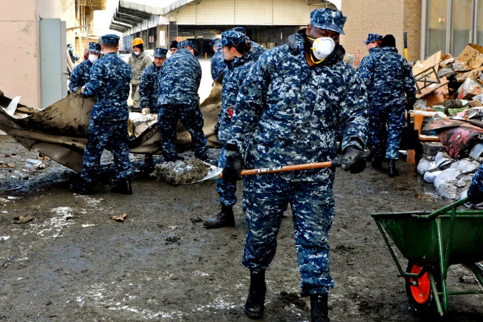 Defense.gov News Photo 110317-N-MU720-019 - U.S. Navy Petty Officer 2nd Class Robert Bannister removes mud sediment from behind a damaged building in Hachinohe Japan on March 17 2011