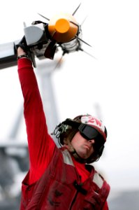 Defense.gov News Photo 110405-N-6505H-082 - Petty Officer 2nd Class Jason Cooley assigned to Strike Fighter Squadron 81 lowers the wing tip of an F A-18E Super Hornet aircraft to offload
