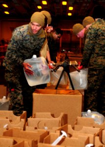 Defense.gov News Photo 110325-N-WJ771-196 - U.S. Marines assigned to the 31st Marine Expeditionary Unit fill plastic containers with potable water in the hangar bay of amphibious assault ship