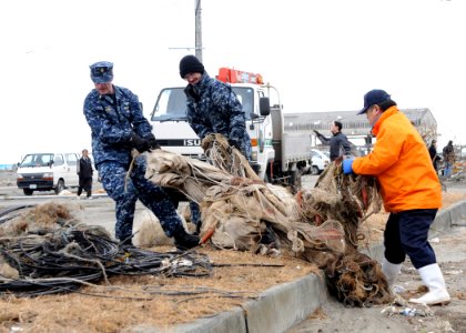 Defense.gov News Photo 110315-N-MU720-094 - Sailors assigned to Naval Air Facility Misawa help a Misawa City employee transport salvageable fishing equipment at the Misawa Fishing Port on
