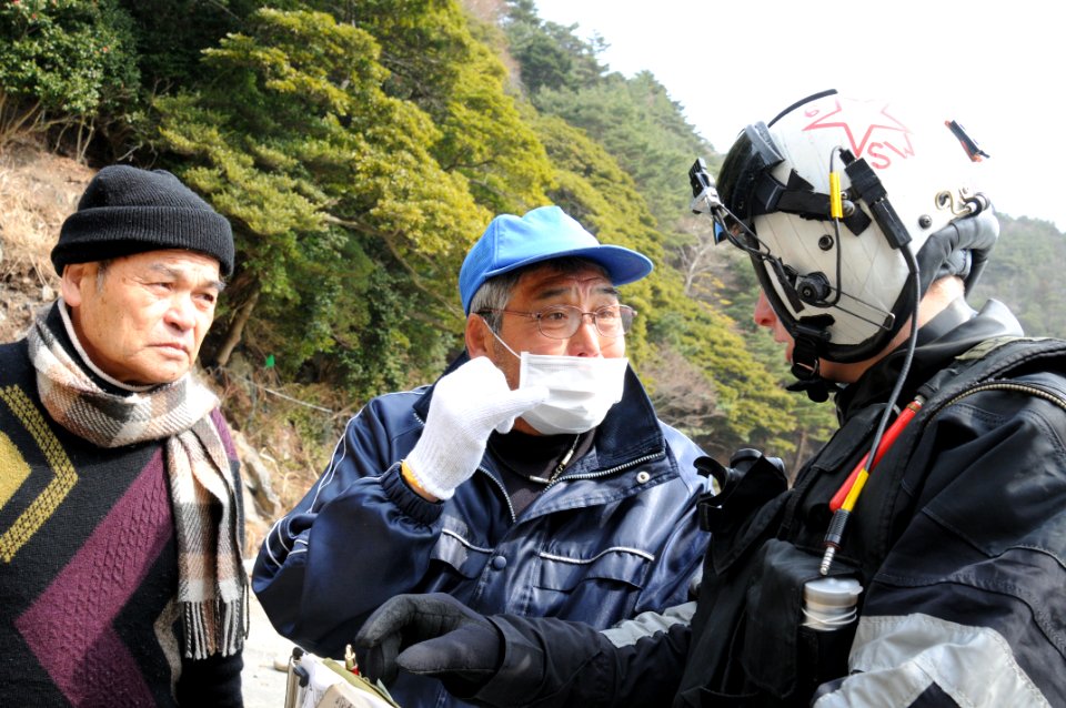 Defense.gov News Photo 110320-N-LV331-388 - U.S. Navy Petty Officer 2nd Class Justin Dowd right with Helicopter Anti-Submarine Squadron 4 speaks with Japanese citizens to identify areas