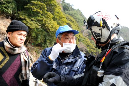 Defense.gov News Photo 110320-N-LV331-388 - U.S. Navy Petty Officer 2nd Class Justin Dowd right with Helicopter Anti-Submarine Squadron 4 speaks with Japanese citizens to identify areas