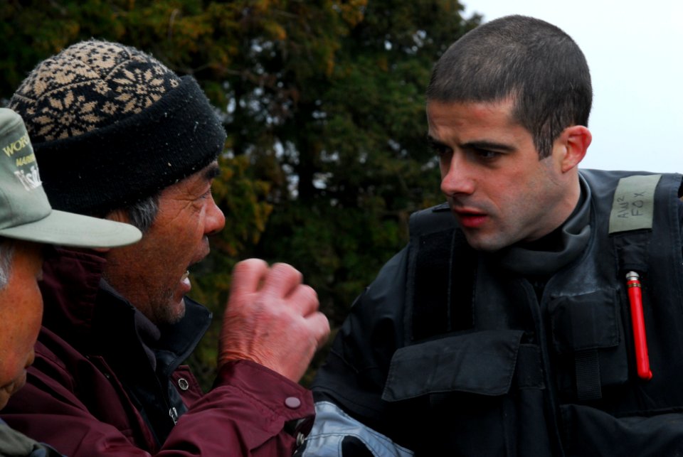 Defense.gov News Photo 110322-N-SB672-644 - U.S. Navy Petty Officer 2nd Class Brian Fox speaks with Japanese men about additional supplies needed in the area in Oshima-mura Japan on March