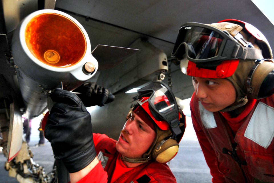 Defense.gov News Photo 110520-N-1004S-996 - U.S. Navy Seaman Korey Chavis left installs wing and fin attachments to an AIM-120 AMRAAM missile while Seaman John Chang right observes aboard the