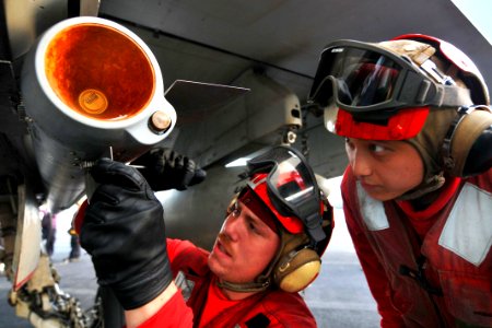 Defense.gov News Photo 110520-N-1004S-996 - U.S. Navy Seaman Korey Chavis left installs wing and fin attachments to an AIM-120 AMRAAM missile while Seaman John Chang right observes aboard the