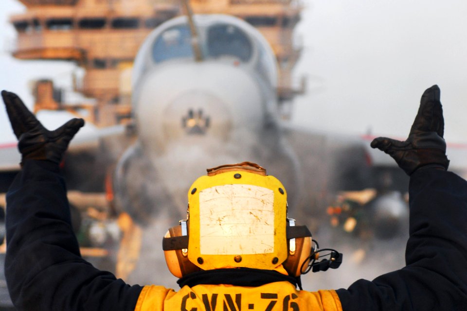 Defense.gov News Photo 110329-N-SB672-196 - U.S. Navy Airman Ryan Hilliard directs an EA-6B Prowler on to catapult one before launching off the flight deck of the aircraft carrier USS Ronald
