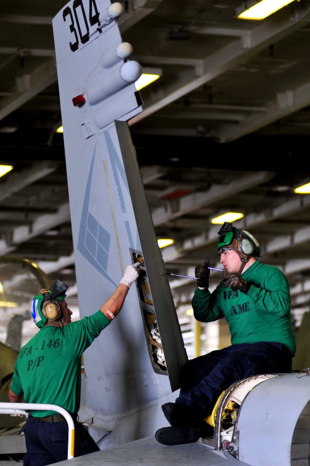 Defense.gov News Photo 110425-N-1004S-117 - Airman German Alulzo left strips sealant out of a rudder as Airman Kells Dean reinstalls a rudder bearing during phase A inspection on an F A-18C