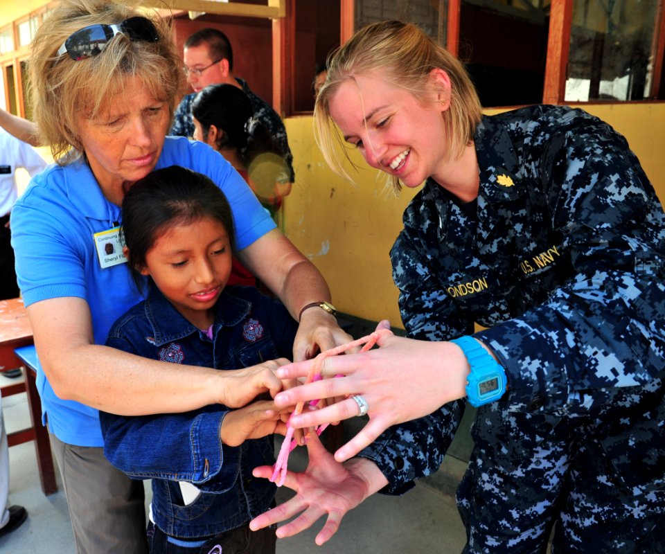 Defense.gov News Photo 110503-N-QD416-114 - Sheryl Flanary left and U.S. Navy Lt. j.g. Sara Edmonson right teach a patient how to play a game at a medical clinic set up by the staff of the