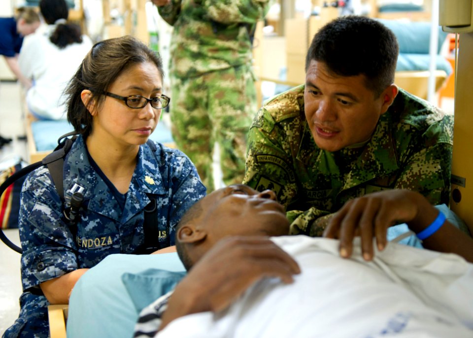 Defense.gov News Photo 110604-N-RM525-082 - U.S. Navy Lt. Cecilia Mendoza left and Rev. Juan Garcia a Roman Catholic priest from the Colombian Navy visit a patient during a tour aboard the