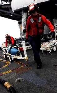 Defense.gov News Photo 110513-N-OY799-122 - Petty Officer 2nd Class Jeffrey Anderson right and Petty Officer 1st Class Michael Washa move ordnance on the flight deck of the aircraft carrier