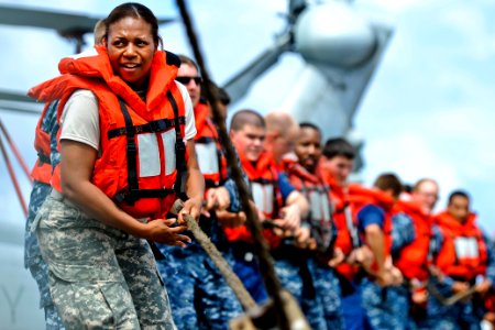 Defense.gov News Photo 110627-N-YM863-353 - U.S. Army Spc. Tracey Hargroves helps haul in lines during a replenishment at sea aboard the amphibious transport dock ship USS Cleveland LPD 7