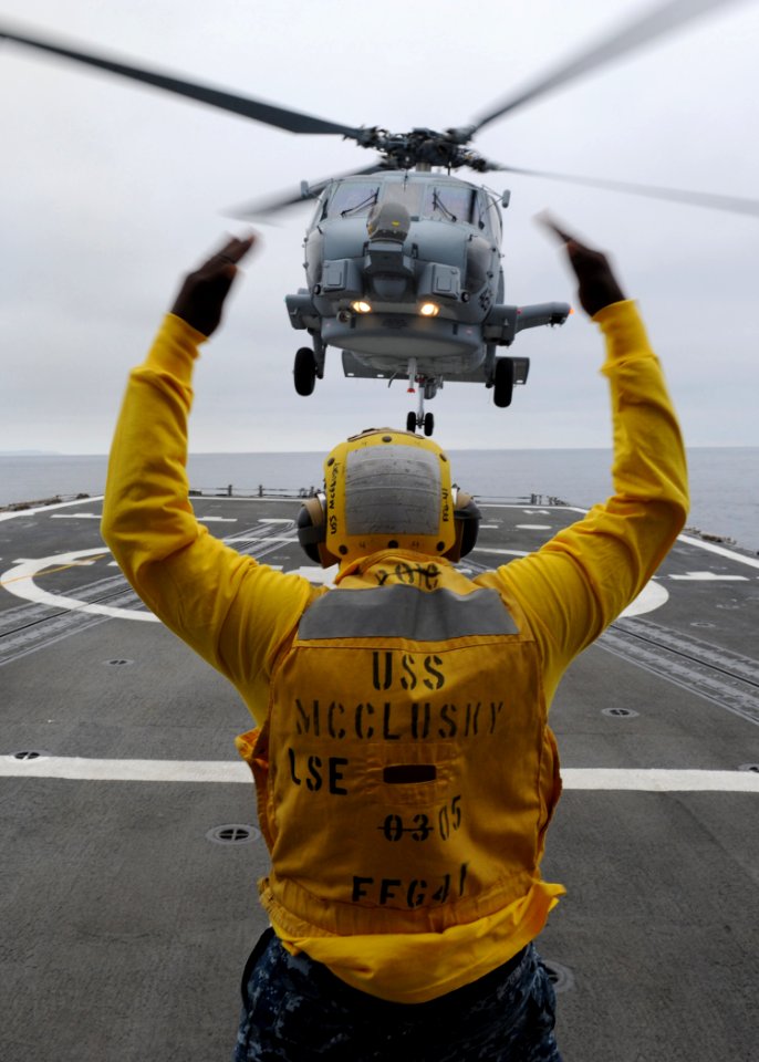Defense.gov News Photo 110624-N-PB383-260 - Petty Officer 3rd Class Lazarus Bullock enlisted landing signalman aboard the guided-missile frigate USS McClusky FFG 41 guides an SH-60R Sea