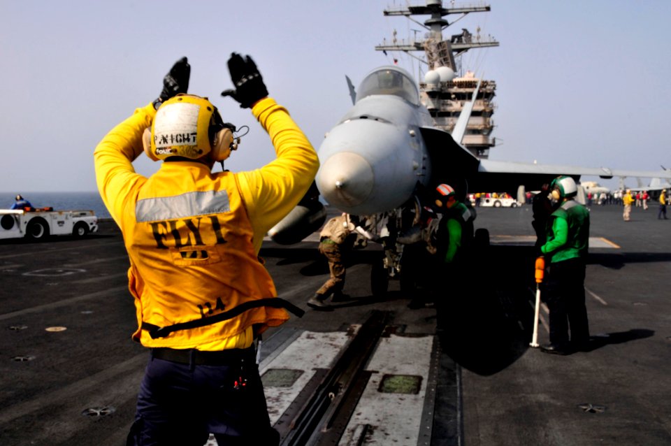 Defense.gov News Photo 110606-N-AV746-450 - Petty Officer 3rd Class Patrick Wight signals to the pilots of an F A-18 aircraft before launching off the flight deck of the aircraft carrier USS