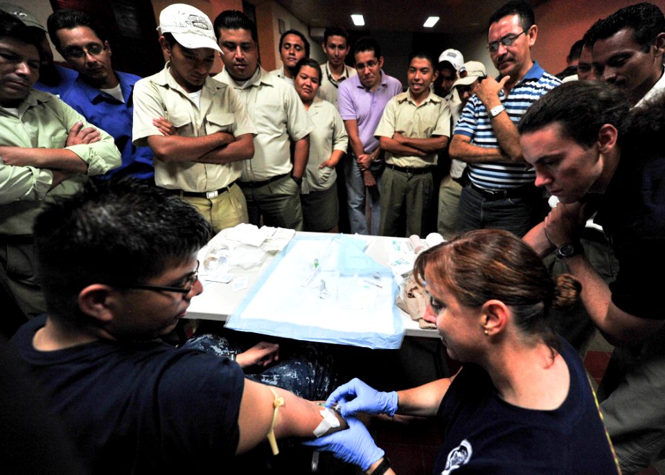 Defense.gov News Photo 110719-N-QD416-045 - U.S. Navy Lt. Cmdr. Rebecca Pate right demonstrates how to insert an IV during a trauma care subject matter expert exchange at Universidad Modular