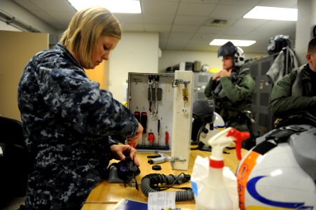 Defense.gov News Photo 110616-N-VE240-057 - U.S. Navy Airman Jessica Tescher left a parachute rigger performs a monthly maintenance check on a pilot s helmet during Exercise Northern Edge