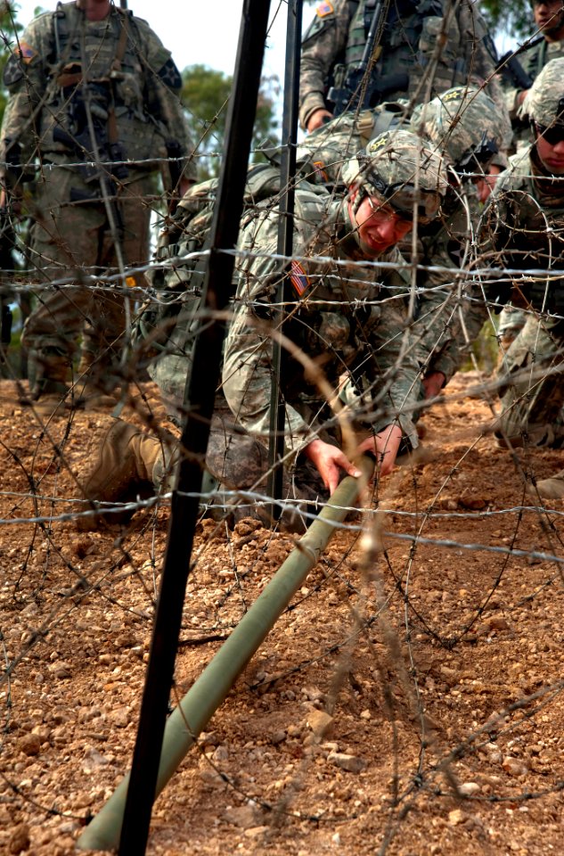 Defense.gov News Photo 110715-N-KG738-614 - U.S. Army soldiers with the 38th Engineer Company 4th Stryker Brigade 2nd Infantry Division place a Bangalore explosive to clear a barbed wire