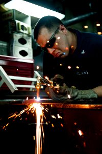 Defense.gov News Photo 110803-N-BT887-180 - U.S. Navy Petty Officer 3rd Class Jeffrey Meginness cuts sheet metal with an acetylene torch aboard the aircraft carrier USS John C. Stennis CVN 74