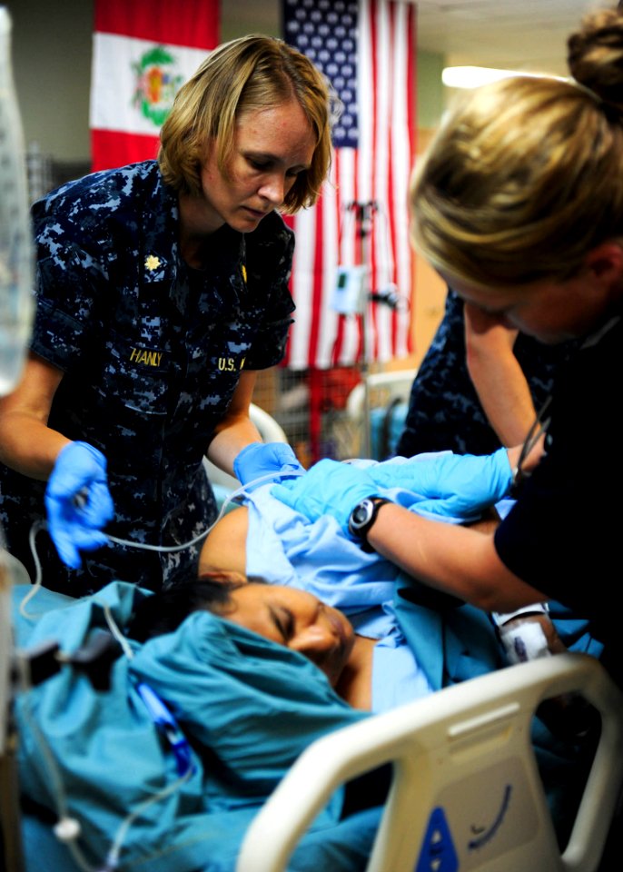 Defense.gov News Photo 110720-N-QD416-041 - U.S. Navy Lt. Cmdr. Marsha Hanly left makes a patient comfortable in the intensive care unit aboard the hospital ship USNS Comfort T-AH 20 in