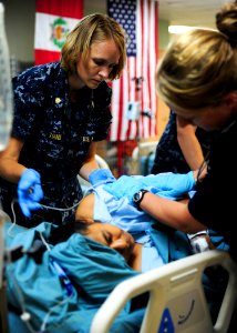 Defense.gov News Photo 110720-N-QD416-041 - U.S. Navy Lt. Cmdr. Marsha Hanly left makes a patient comfortable in the intensive care unit aboard the hospital ship USNS Comfort T-AH 20 in